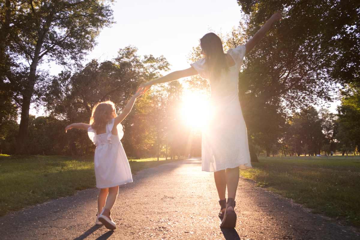 mother and child reconnecting outdoors during court-ordered reunification therapy on a sunny afternoon