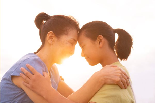 mother and daughter reconnecting emotionally during a court-ordered reunification therapy session at sunset