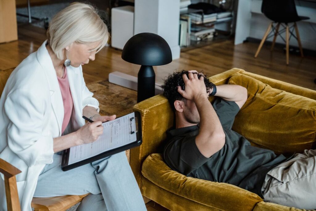 Forensic psychology expert listening to a male client during therapy.
