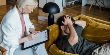 Forensic psychology expert listening to a male client during therapy.