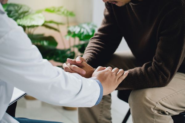 A forensic psychologist calmly reassures his client.
