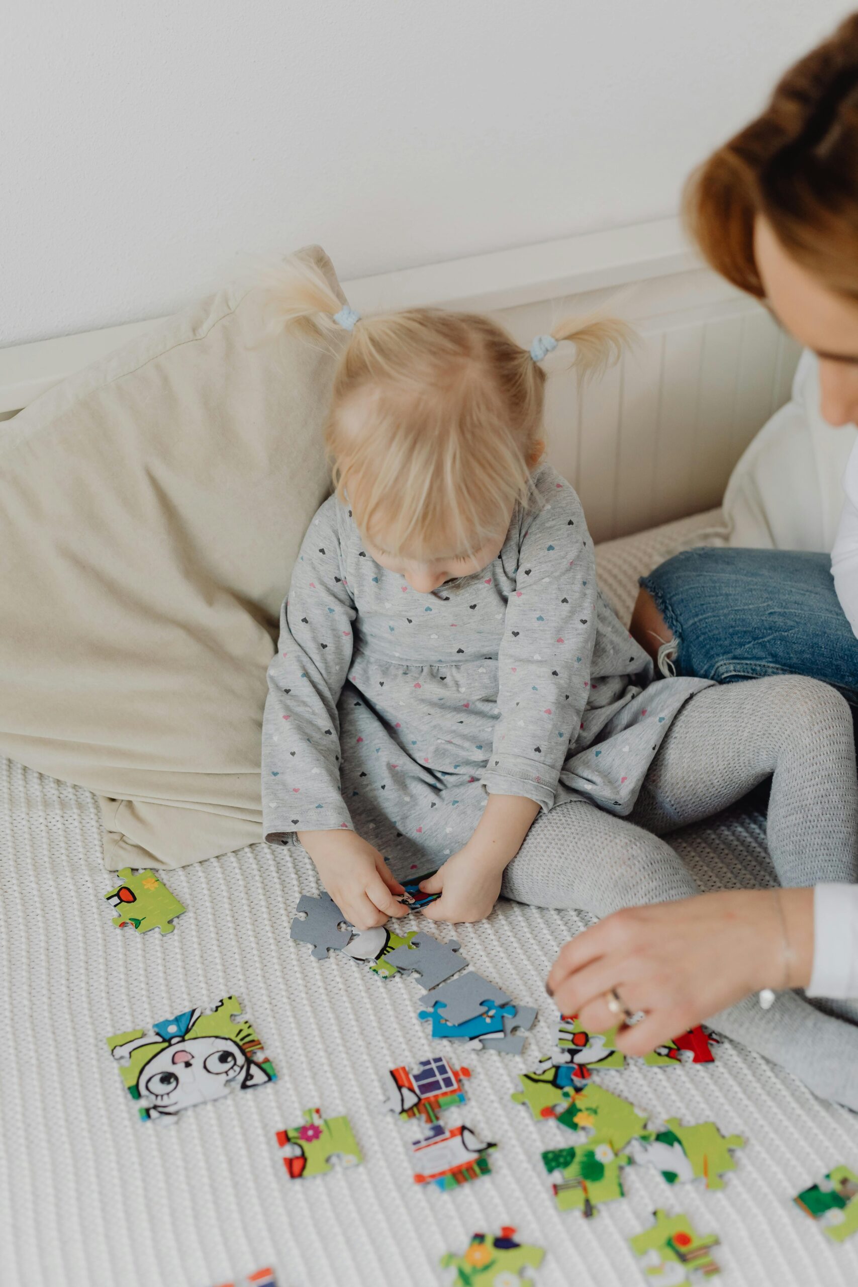 a child playing puzzles with her mom