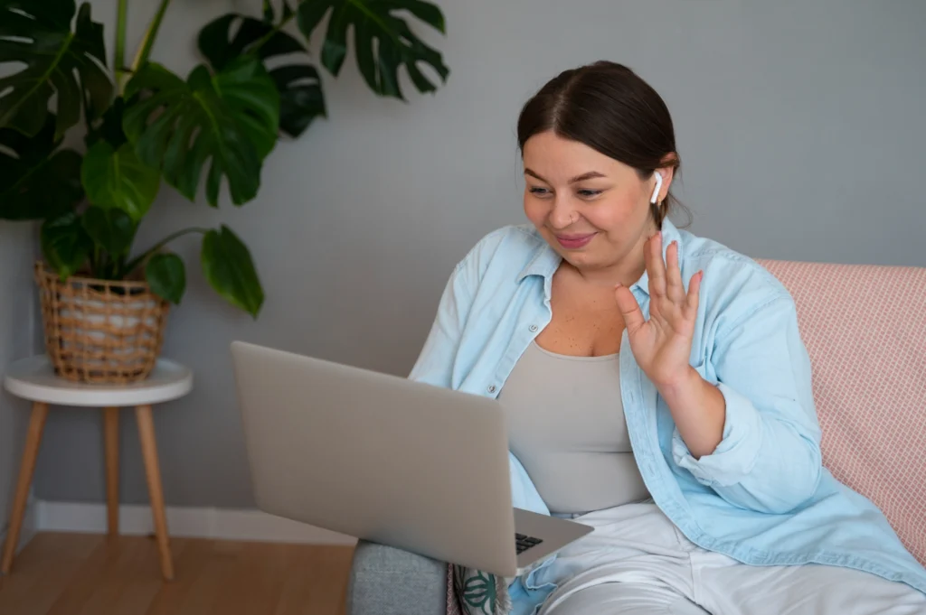 Woman waving during an online forensic evaluation session